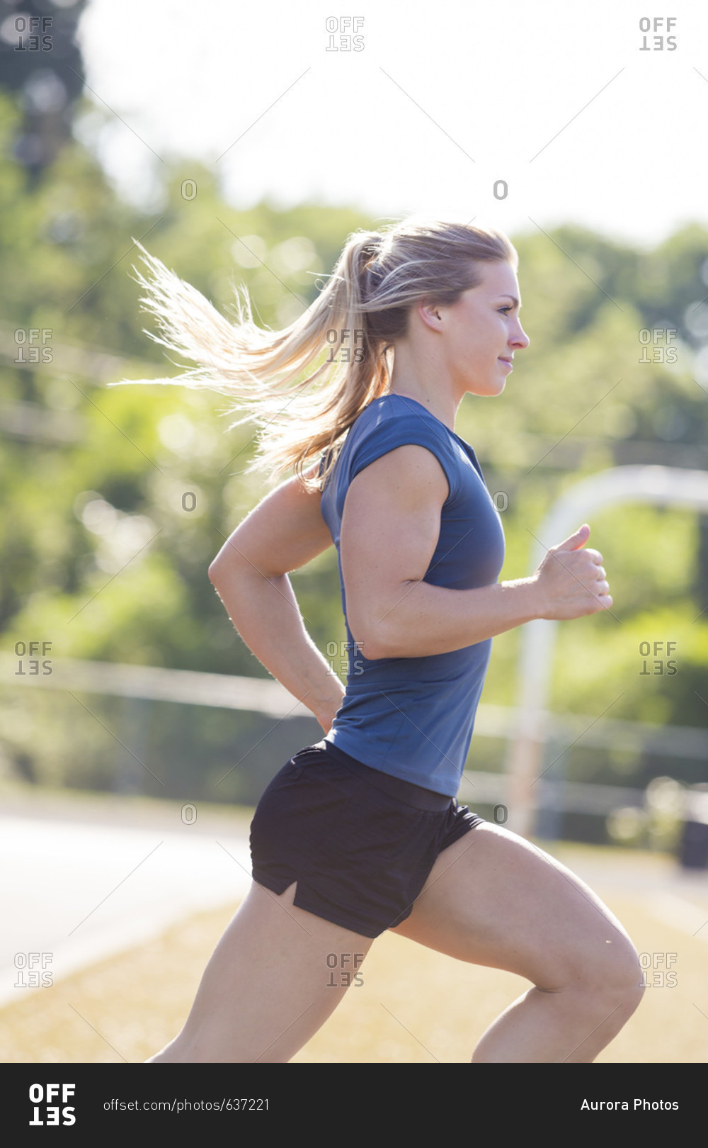 Side view of blonde female runner with ponytail in shirt and shorts, Eugene, Oregon, USA