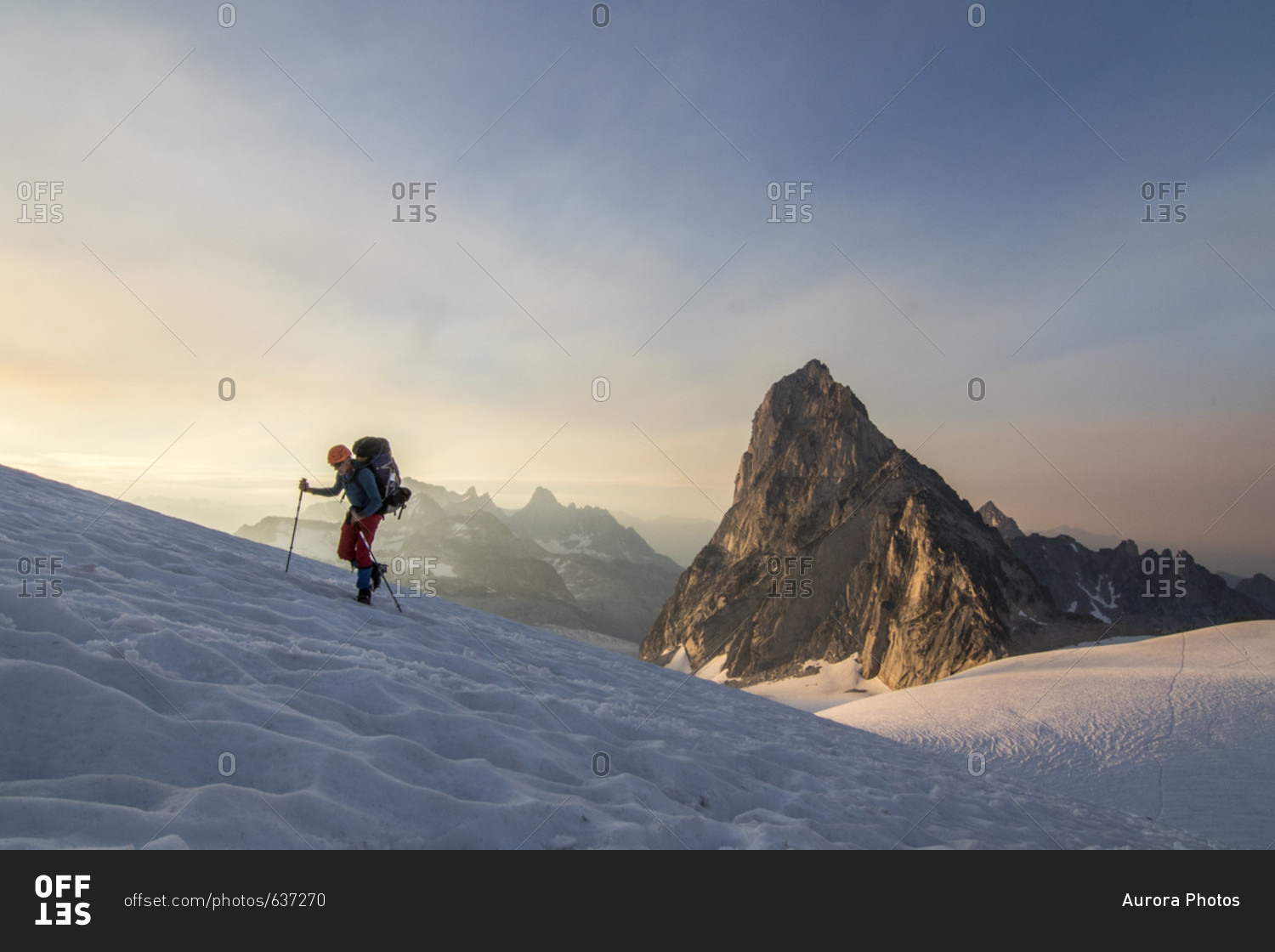Side view of mountain climber traversing Vowell Glacier at sunset, Bugaboo Mountains, British Columbia, Canada