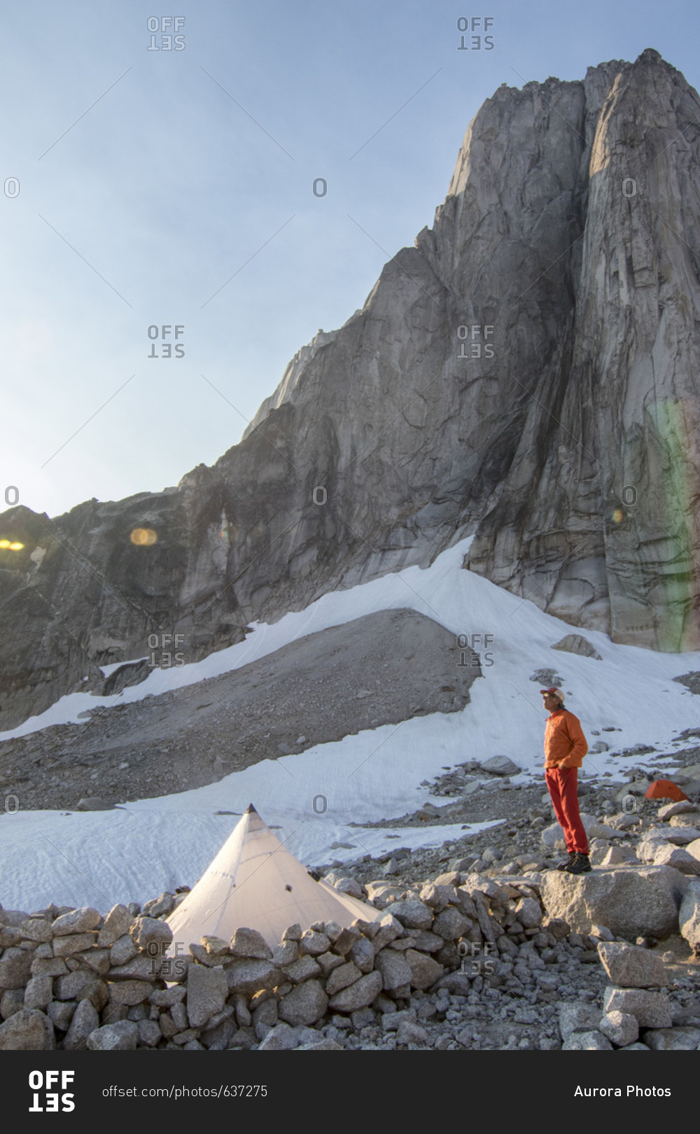 Mountain climber with tent below Beckey-Chouinard, Bugaboo Mountains, British Columbia, Canada
