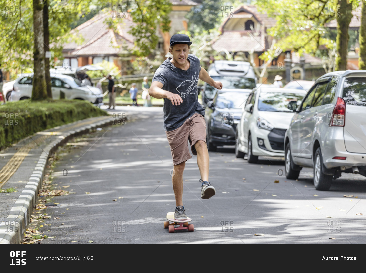 Front view of man with skateboard on street, Bedugul, Bali, Indonesia