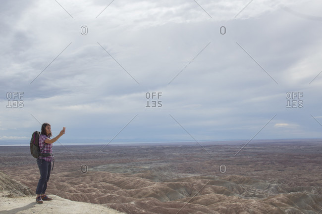 Adult woman taking selfie against badlands of Anza Borrego State Park, California, USA