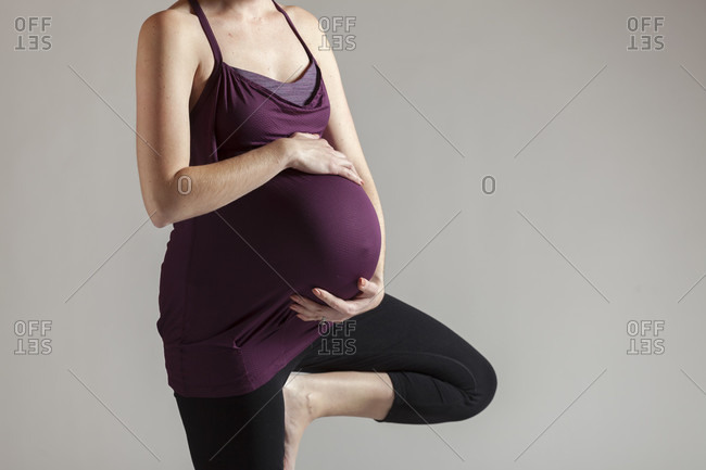 Mid section view of woman doing Prenatal Yoga in tree pose, Boston, Massachusetts, USA