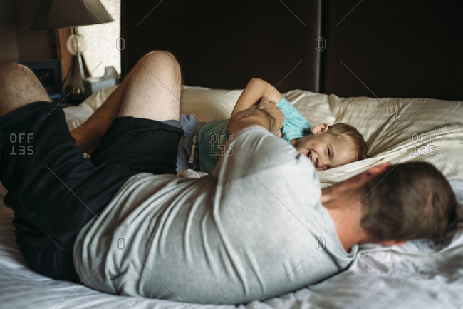 Father and son playing on bed