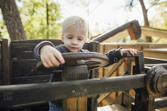 Cute boy playing on play equipment at park