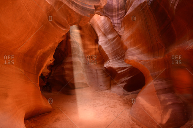 Sandstone slot canyon illuminated by shafts of sunlight
