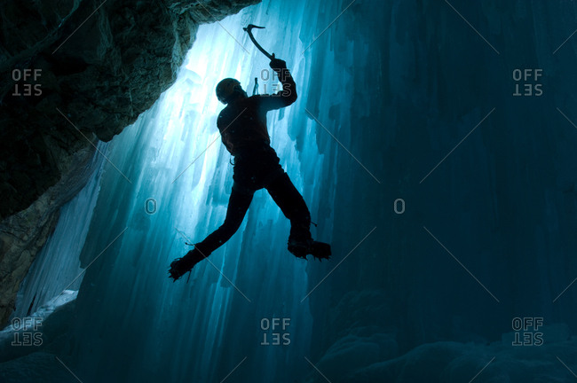 An ice climber climbing a frozen waterfall