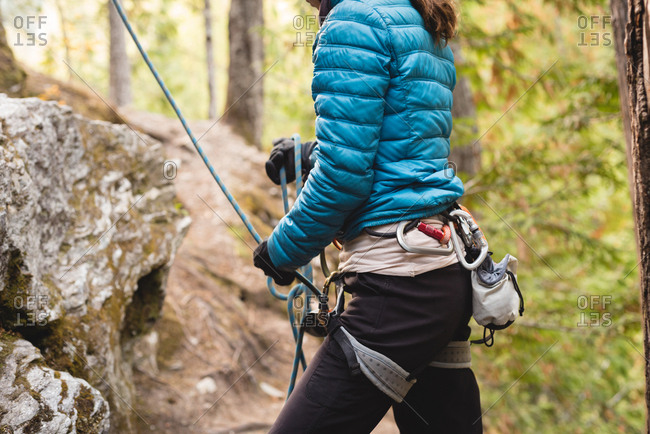 Mid section of female climber preparing herself to climb the cliff