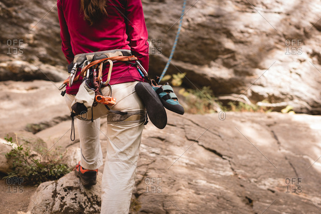 Rear view of female hiker preparing herself to climb the rocky mountain