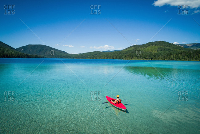 Kayaker kayaking in shallow turquoise water