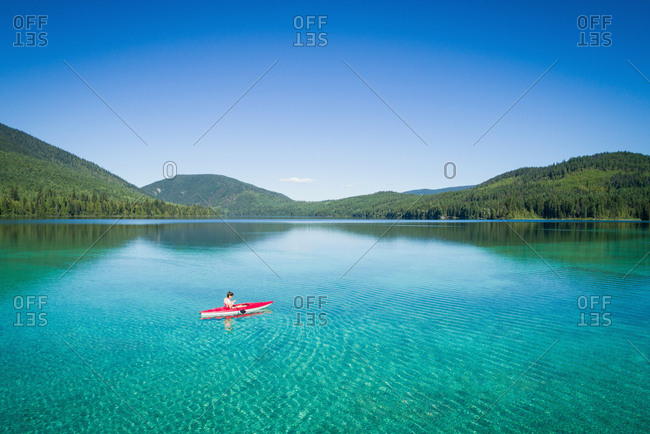 Kayaker kayaking in shallow turquoise water