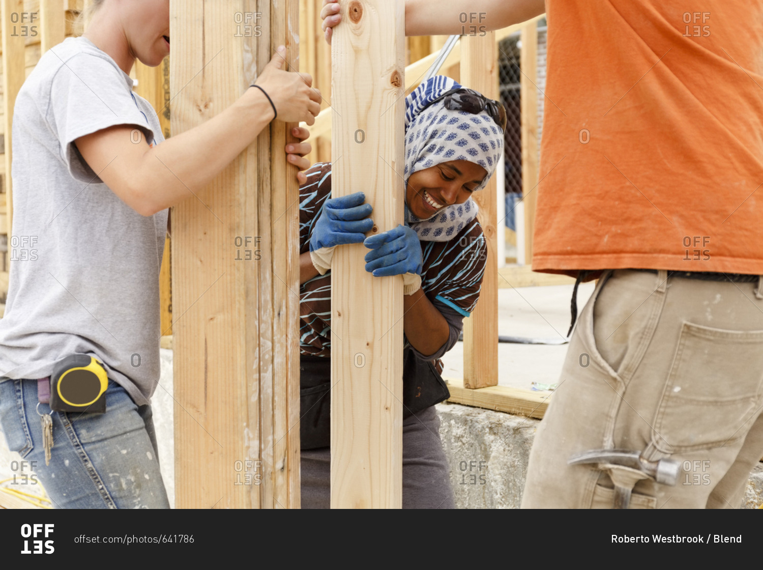 Volunteers holding lumber at construction site