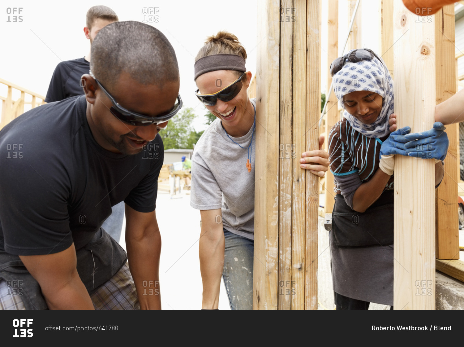 Volunteers holding lumber at construction site