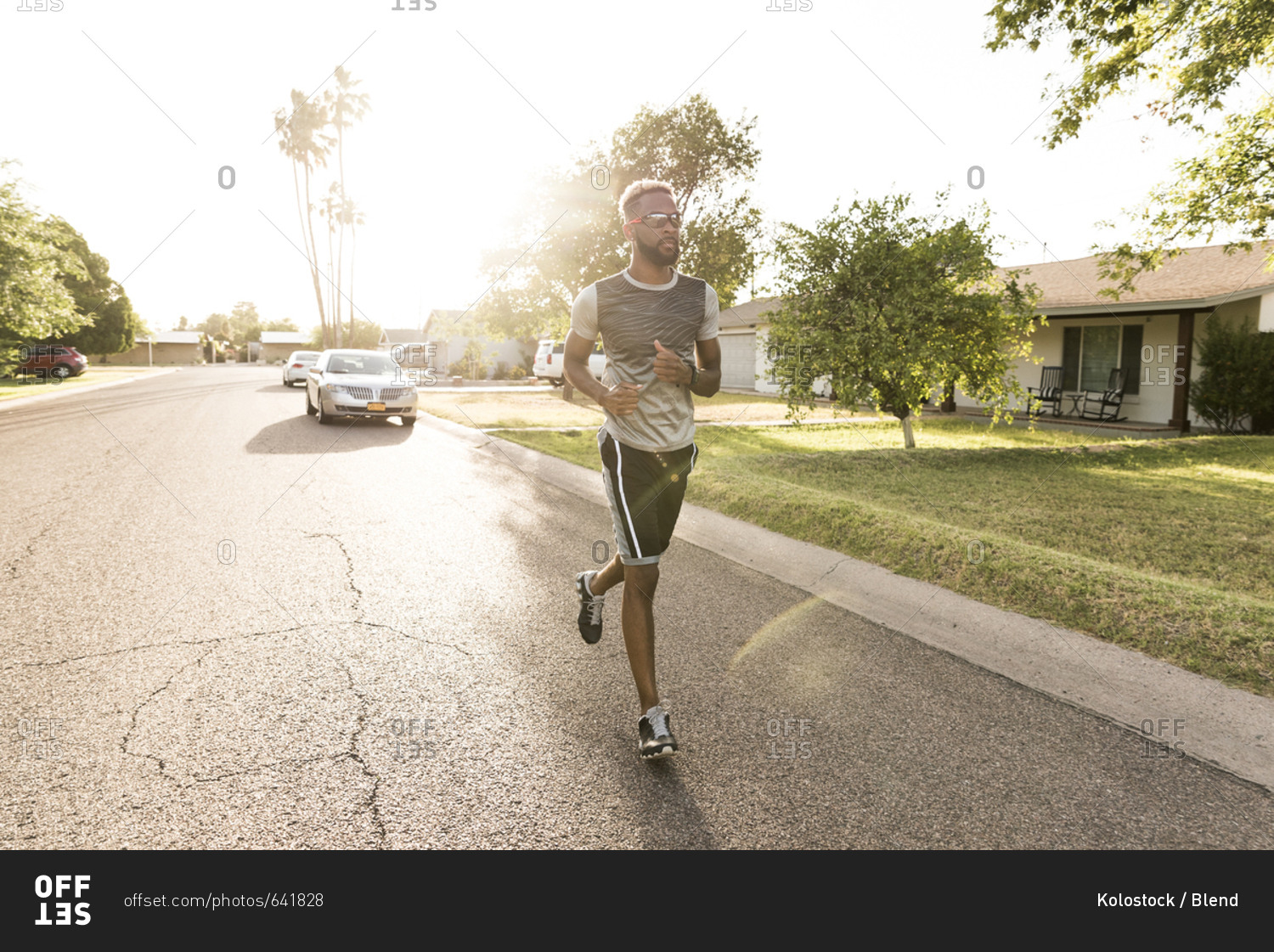 Black man running on street in neighborhood