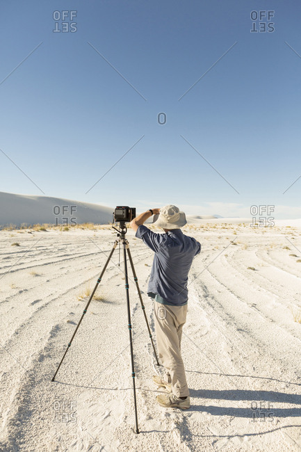 Caucasian photographer with tripod in desert