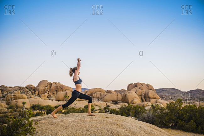 Hispanic woman performing yoga in desert
