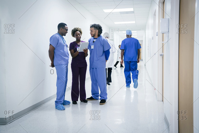 Nurses discussing digital tablet in hospital