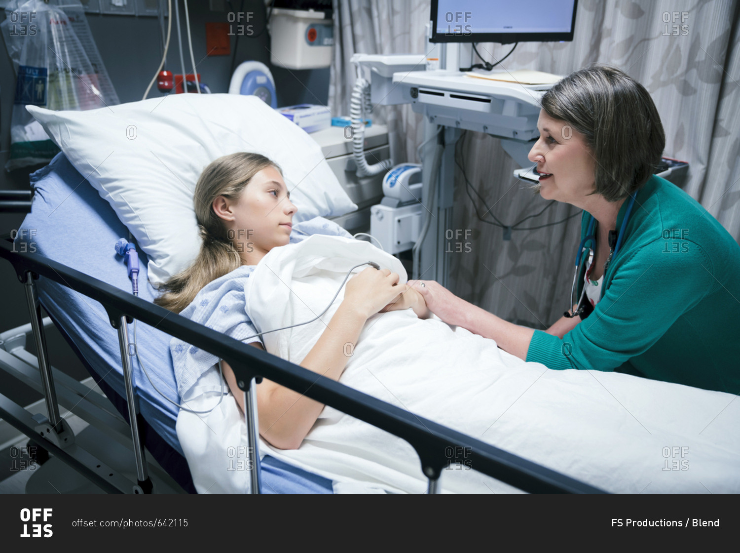 Caucasian doctor comforting patient in hospital bed stock photo - OFFSET