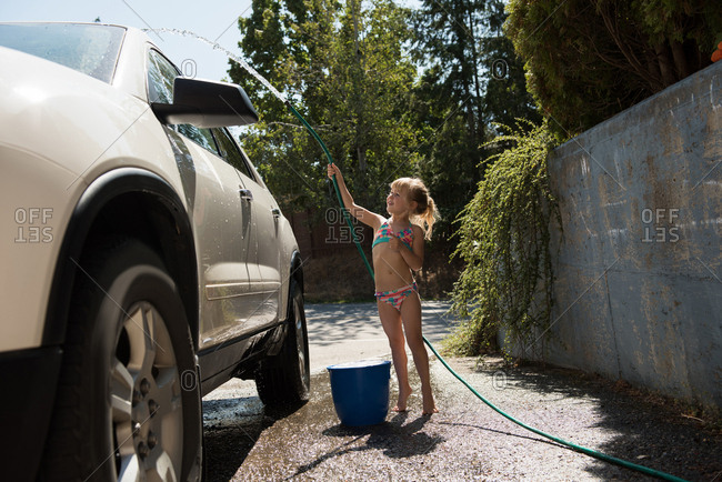 Girl Washing A Car At Outside Garage On A Sunny Day Stock Photo OFFSET