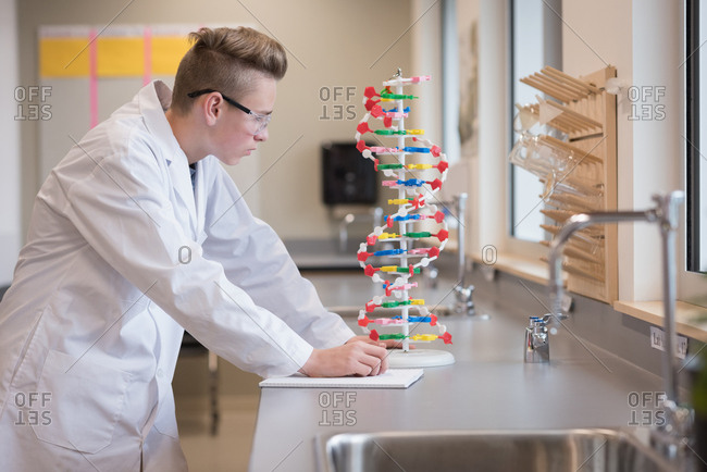 Teenage boy experimenting molecule model in laboratory