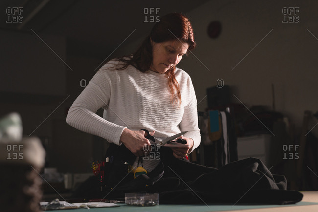 Tailor Cutting Clothes With Scissors At Workshop Stock Photo Offset