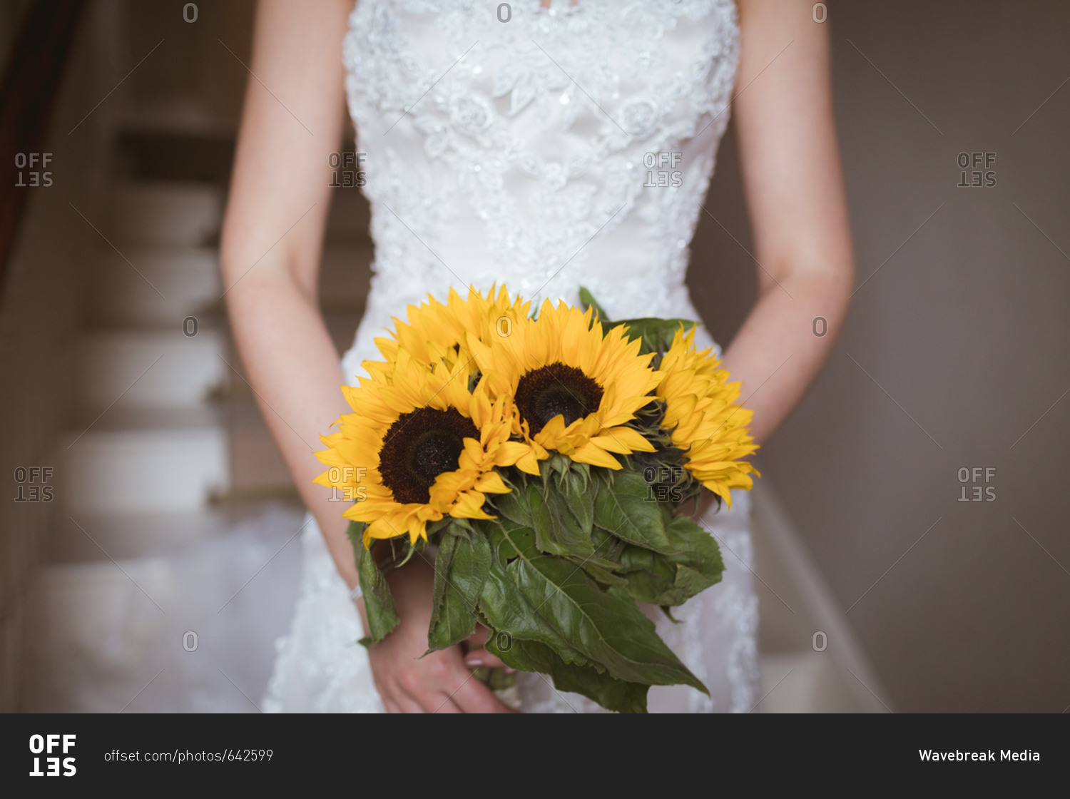 Mid section of bride holding a flower bouquet