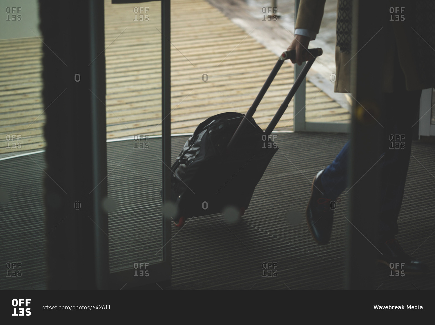 Businessman arriving in hotel with trolley bag