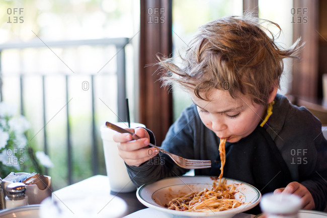 Little boy eating messy spaghetti