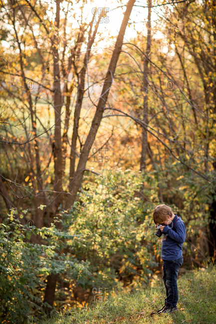 Boy taking pictures in the woods