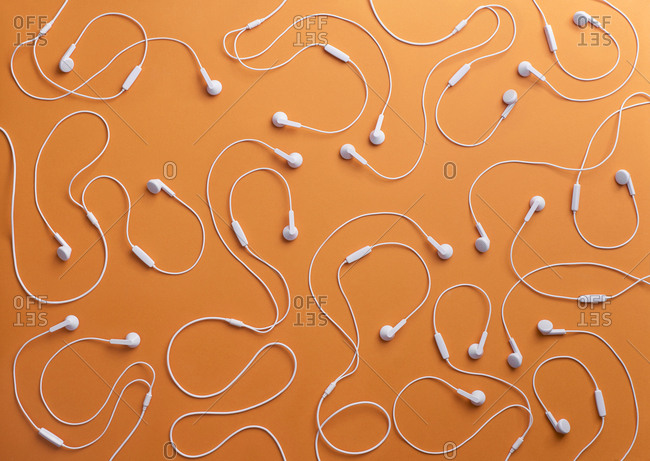 White earphones on orange background- 3D Rendering