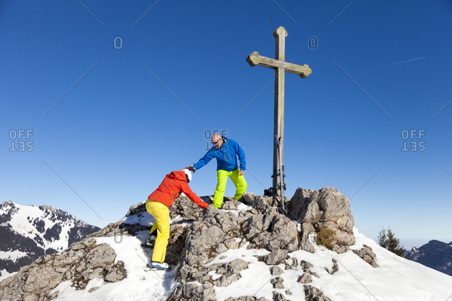 Ski holiday, Two skiers arriving mountain peak, Sudelfeld, Bavaria, Germany