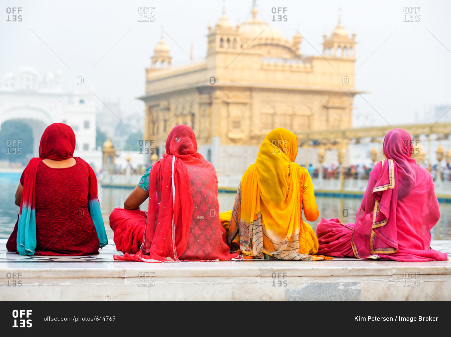Sikh women pilgrims sitting in front of the Harmandir Sahib or Golden Temple, Amritsar, Punjab, India, Asia