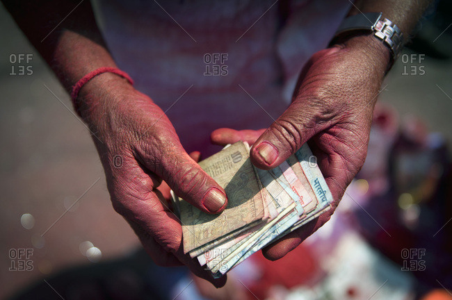 Indian rupees in the hands of a kum kum powder vendor, Calcutta, Kolkata, West Bengal, India, Asia