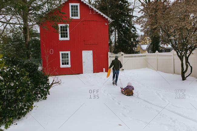 Children play with sled in backyard