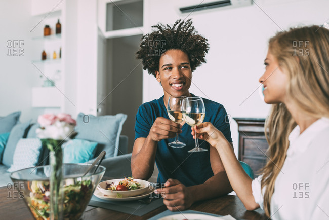 Happy young in love interracial couple celebrating with a romantic lunch on Valentine\'s day at home