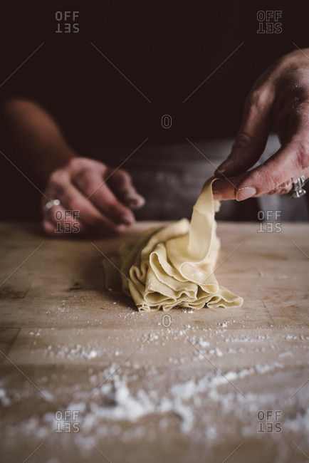 Person preparing a sheet of freshly made pasta dough