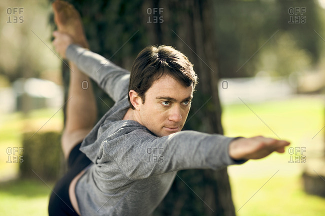 Focused middle aged man practicing yoga in the park