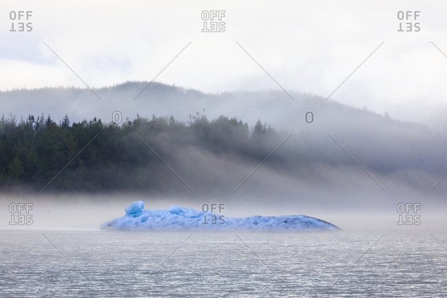 Bright blue iceberg from Mendenhall Glacier, surrounded by mist on Mendenhall Lake, Juneau, Alaska, United States of America, North America