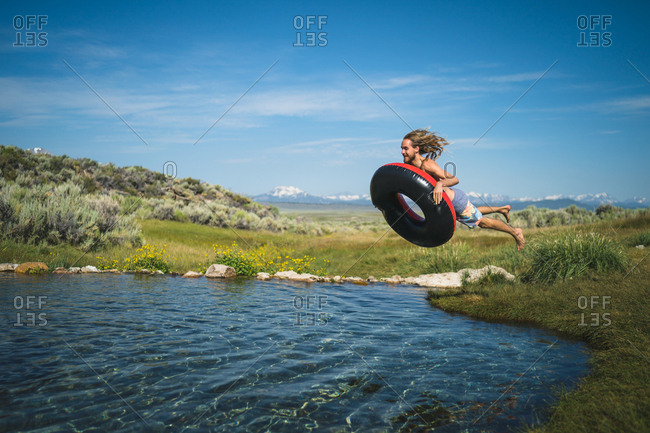 Man With Inflatable Ring Jumping In Lake
