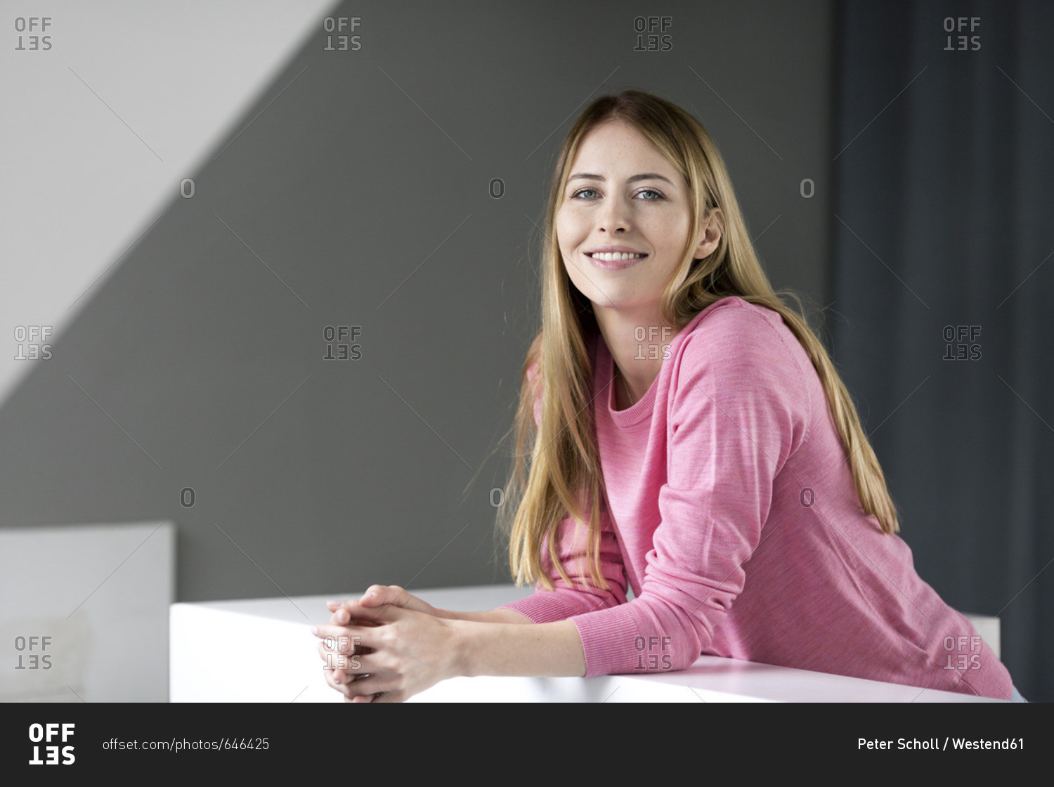 Portrait of smiling young woman wearing pink pullover