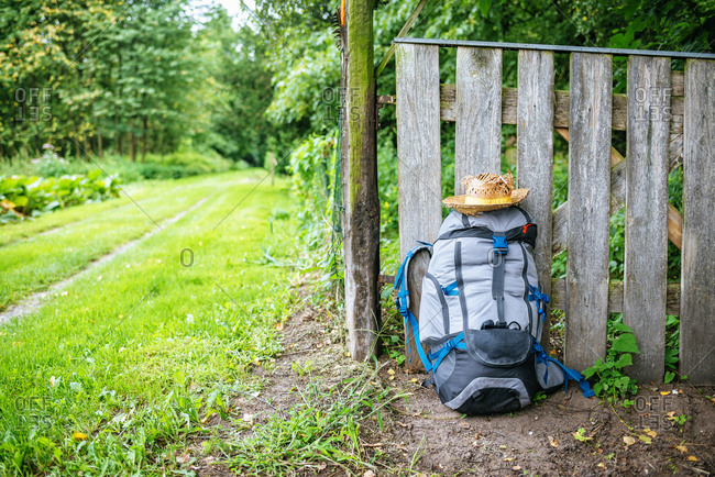 France- Strasbourg- travel backpack and straw hat in front of wooden fence on the way