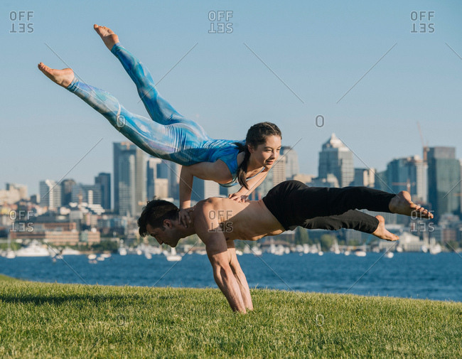 Teenage girl and young man, outdoors, man balancing on hands, girl balancing on hands on man's back