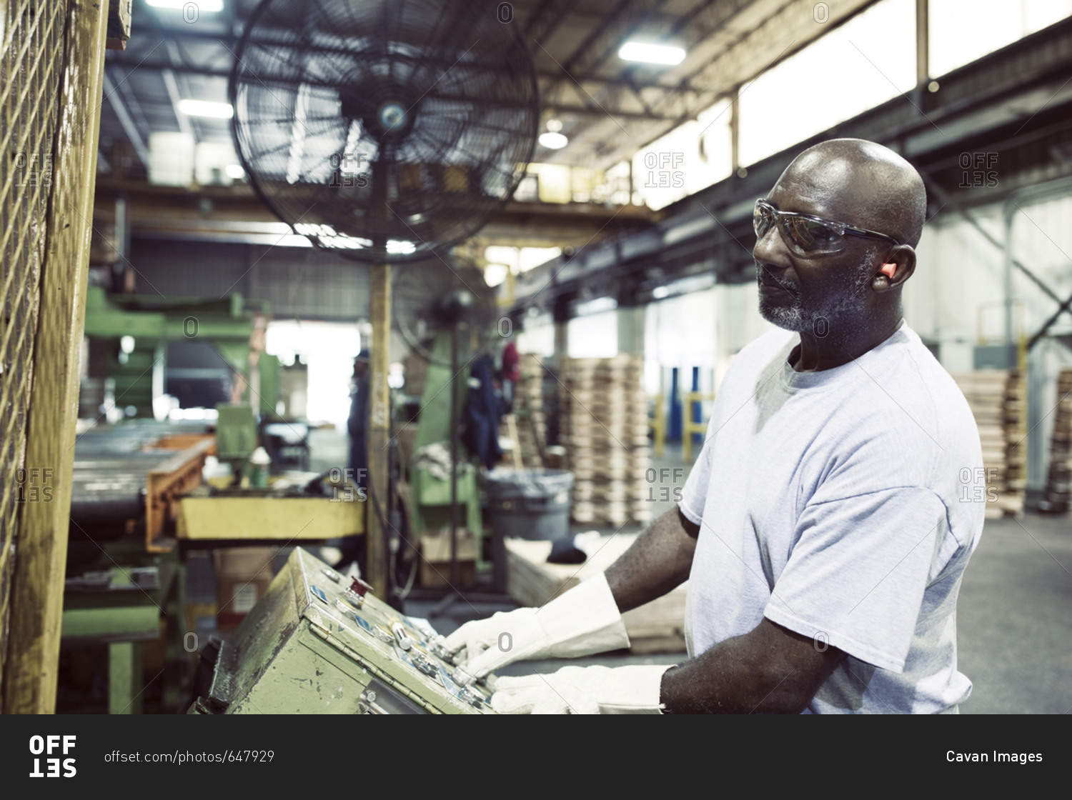 Manual worker using machine while working in steel industry stock photo
