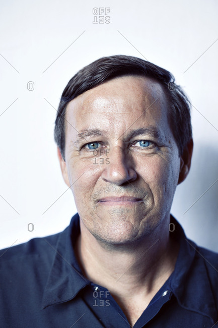 Close-up portrait of mature worker against white background
