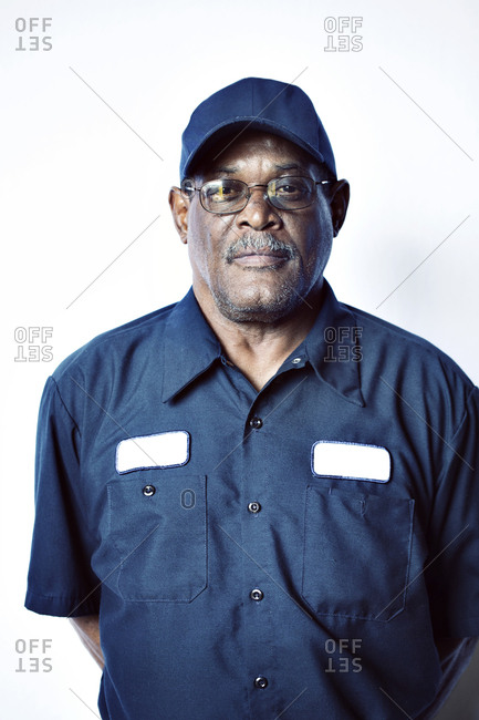 Portrait of smiling senior worker standing against white background