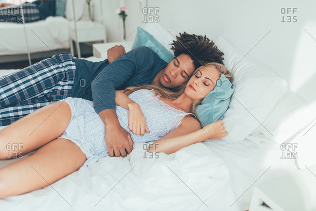 Young beautiful interracial couple in bed sleeping