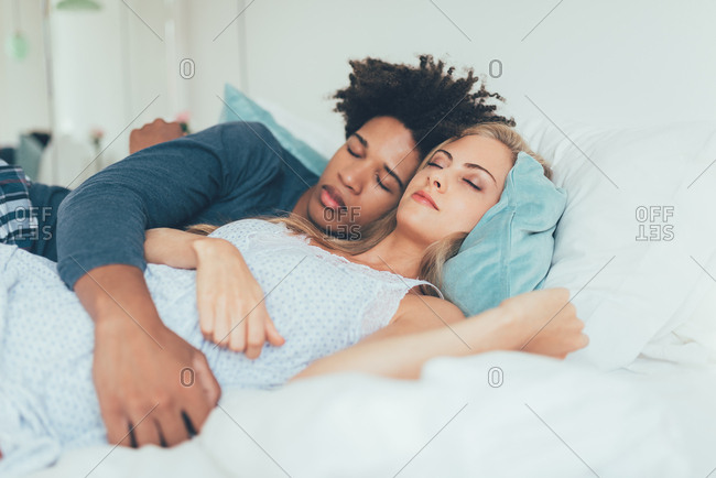Young beautiful interracial couple in bed sleeping