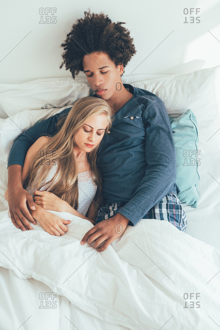 Young beautiful interracial couple in bed sleeping