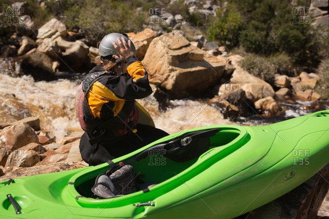 Woman sitting with kayak boat on a sunny day
