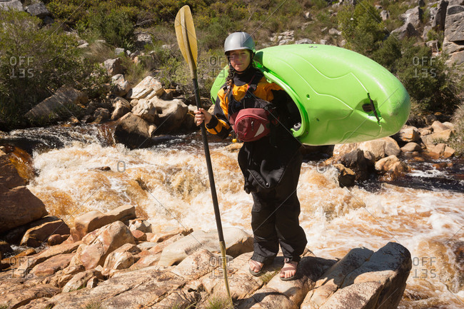 Woman standing with kayak boat on a sunny day