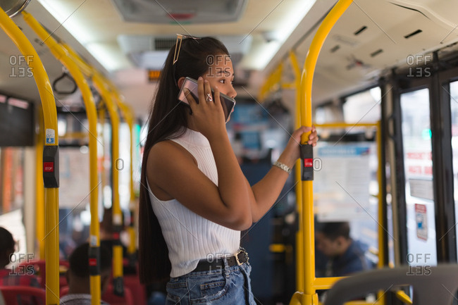 Teenage girl talking on mobile phone in the bus